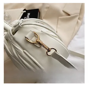 Detail of premium golden metal hook on white pleated drawstring bucket bag