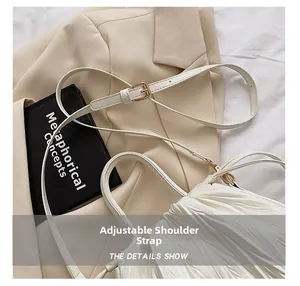 Detailed view of the white pleated bucket bag featuring an adjustable metal buckle strap