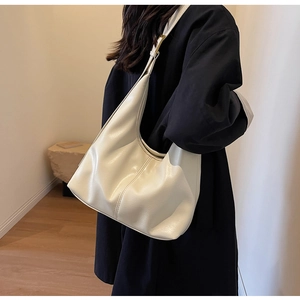 Détail d'un sac Hobo crème en similicuir avec boucle dorée réglable élégante