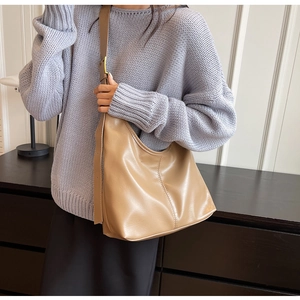 Sac hobo kaki porté par un mannequin avec une large bandoulière et cuir synthétique lisse