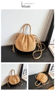 Detailed close-up of khaki pleated cloud bucket bag with textured leather and drawstring