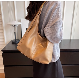 Vue latérale du grand sac seau hobo en cuir PU kaki porté par un mannequin à domicile