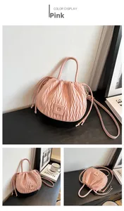 Detail of pink pleated drawstring bucket bag with rhombus embossing and leather patch