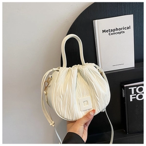 Detailed close-up of white pleated cloud bag with elegant square buckle and carry handle
