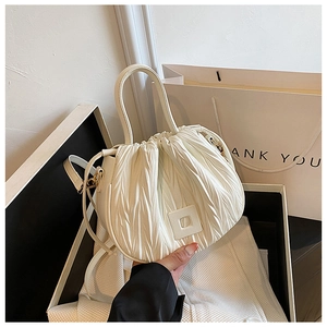 Detail of white pleated texture and elegant square buckle on this versatile bucket bag