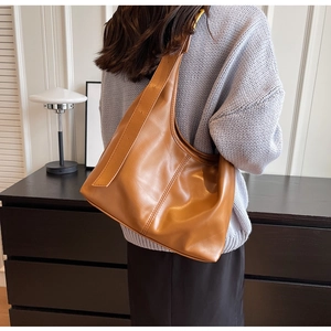 Détail du sac hobo marron caramel montrant la texture du cuir synthétique et les coutures