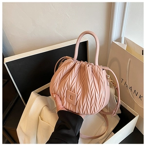 Detail of pink matelassé pleated handbag with curved handle in a stylish gift box