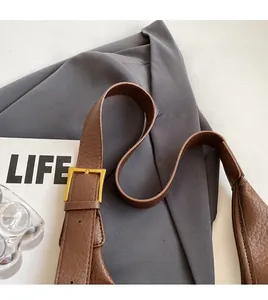 Detail of adjustable brown leather strap with premium gold metal buckle for bucket bag