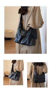 Detail showing the textured black leather surface and large capacity hobo bag design