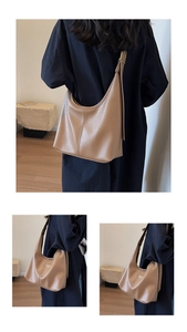 Detail view of brown pebbled leather hobo bag with wide strap and gold hardware