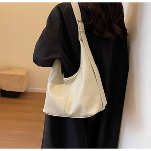 Detail of adjustable metal buckle on beige leather hobo bag with lychee texture