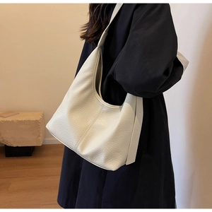 Chic beige lychee grain leather hobo bag worn on shoulder for stylish daily commute