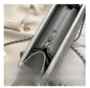 Detail view of smooth silver zipper closure on a metallic quilted chain shoulder bag