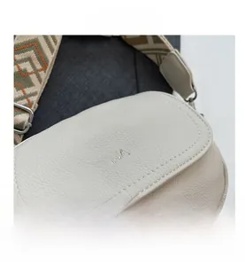 Détail du sac bandoulière en cuir blanc cassé avec large sangle géométrique vintage