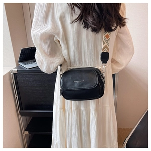 Détail du sac à bandoulière en cuir grainé noir avec sangle tissée géométrique