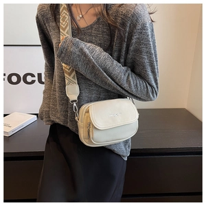 Détail du sac bandoulière beige texture litchi avec large sangle géométrique ajustable