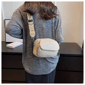 Vue détaillée du petit sac bandoulière beige avec large sangle tissée à motifs géométriques