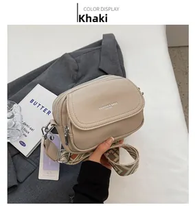 Détails du sac bandoulière kaki avec texture grainée et sangle tissée géométrique