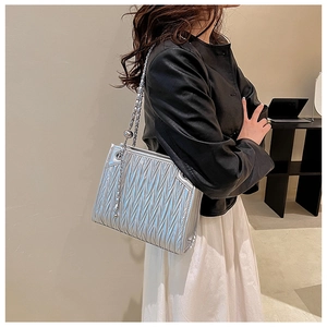 Silver pleated shoulder bag featuring a metallic chain strap and a decorative round ball pendant