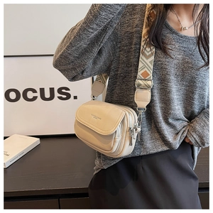 Détail de sac à bandoulière beige avec large sangle tissée aux motifs ethniques