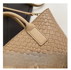 Close-up of precise stitching and premium leather weaving on this khaki tote bag handle