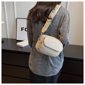 Détail du sac bandoulière blanc cassé avec large bandoulière tissée à motif géométrique