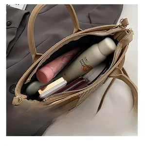 Detail view of large woven tote bag interior showing capacity with wallet and cosmetics