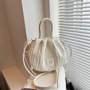 White pleated bucket bag with drawstring closure and stylish crossbody shoulder strap