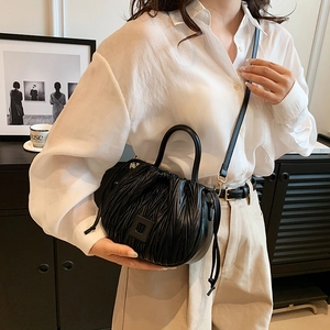 Chic black pleated drawstring bucket bag with square buckle and thin leather strap