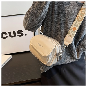 Détail du sac bandoulière en cuir blanc cassé avec sangle jacquard géométrique bohème
