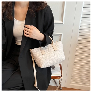 Close-up of creamy white woven texture and sturdy handle on this minimalist tote bag