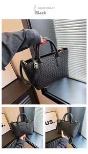 Detail of the black woven tote bag with intricate leather texture and golden metal hardware