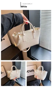 Detailed view of woven white leather tote bag featuring golden metal strap buckles