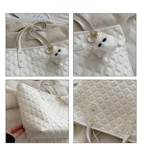 Détails du sac cabas matelassé blanc avec breloque en peluche et textures de couture