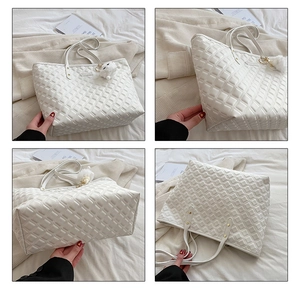 Détails du cabas matelassé blanc avec motifs en losange et pompon décoratif doux