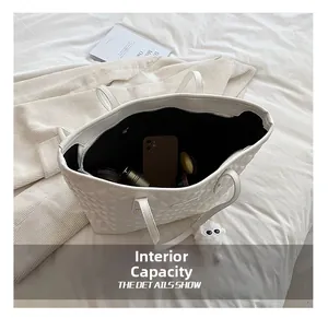 Vue détaillée de l'intérieur spacieux d'un cabas matelassé blanc avec poche zippée