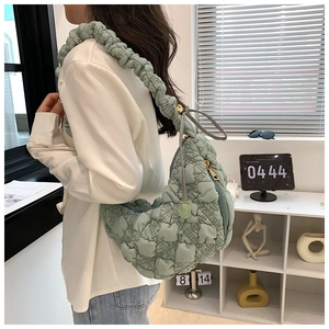 Détail du sac croissant matelassé vert clair avec bandoulière plissée texturée