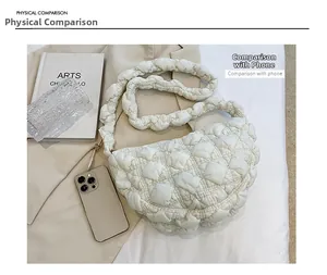 Comparaison de taille du sac nuage matelassé blanc avec un smartphone sur fond beige
