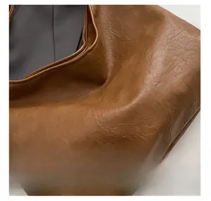 Detailed close-up of brown vintage soft PU leather texture on large capacity bucket bag