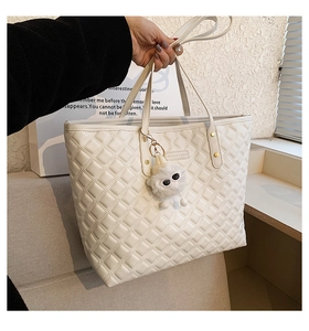 Détail du sac cabas matelassé blanc avec breloque monstre en peluche douce