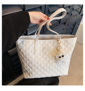 Détail du grand sac cabas blanc matelassé avec charme décoratif pompon de monstre