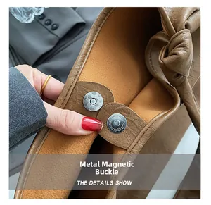 Detail of brown lychee grain leather bag showing hardware magnetic clasp and suede lining