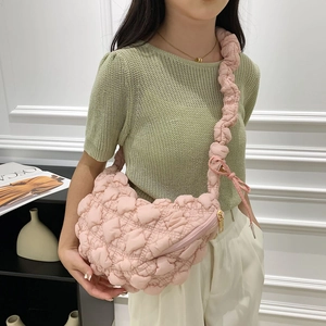 Détail du sac bouffant matelassé rose montrant le tissu texturé et la bandoulière plissée