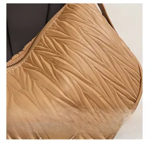 Detail shot of caramel pleated leather texture with premium stitching and gold zipper