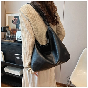 Retro black PU leather crescent hobo bag shown from a 45-degree side view on model