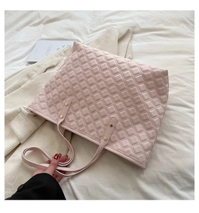 Gros plan détaillé du sac cabas matelassé rose avec clous dorés sur coton doux