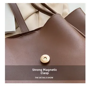 Close-up of golden magnetic snap closure on textured brown faux leather tote bag