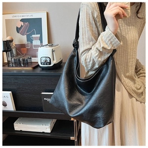 Close-up of a large black leather Hobo bag with stylish knotted shoulder strap detail
