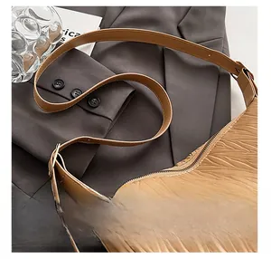 Detail shot of the pleated camel shoulder bag with comfortable strap and metal buckle