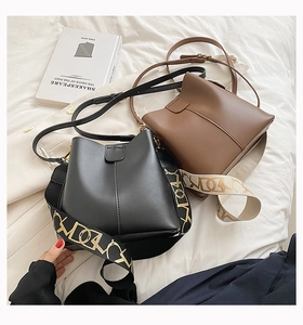 Détail du sac seau minimaliste avec bandoulière large en jacquard et fine sangle en cuir